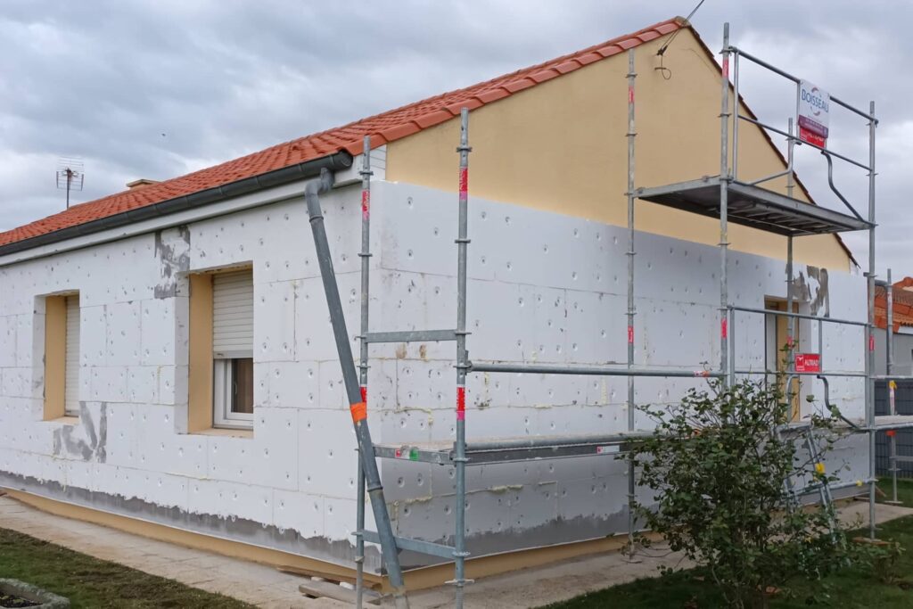Ravalement de façade avec isolation thermique par l’extérieur, montrant la pose des panneaux isolants et la préparation du support avant l’enduit de finition.