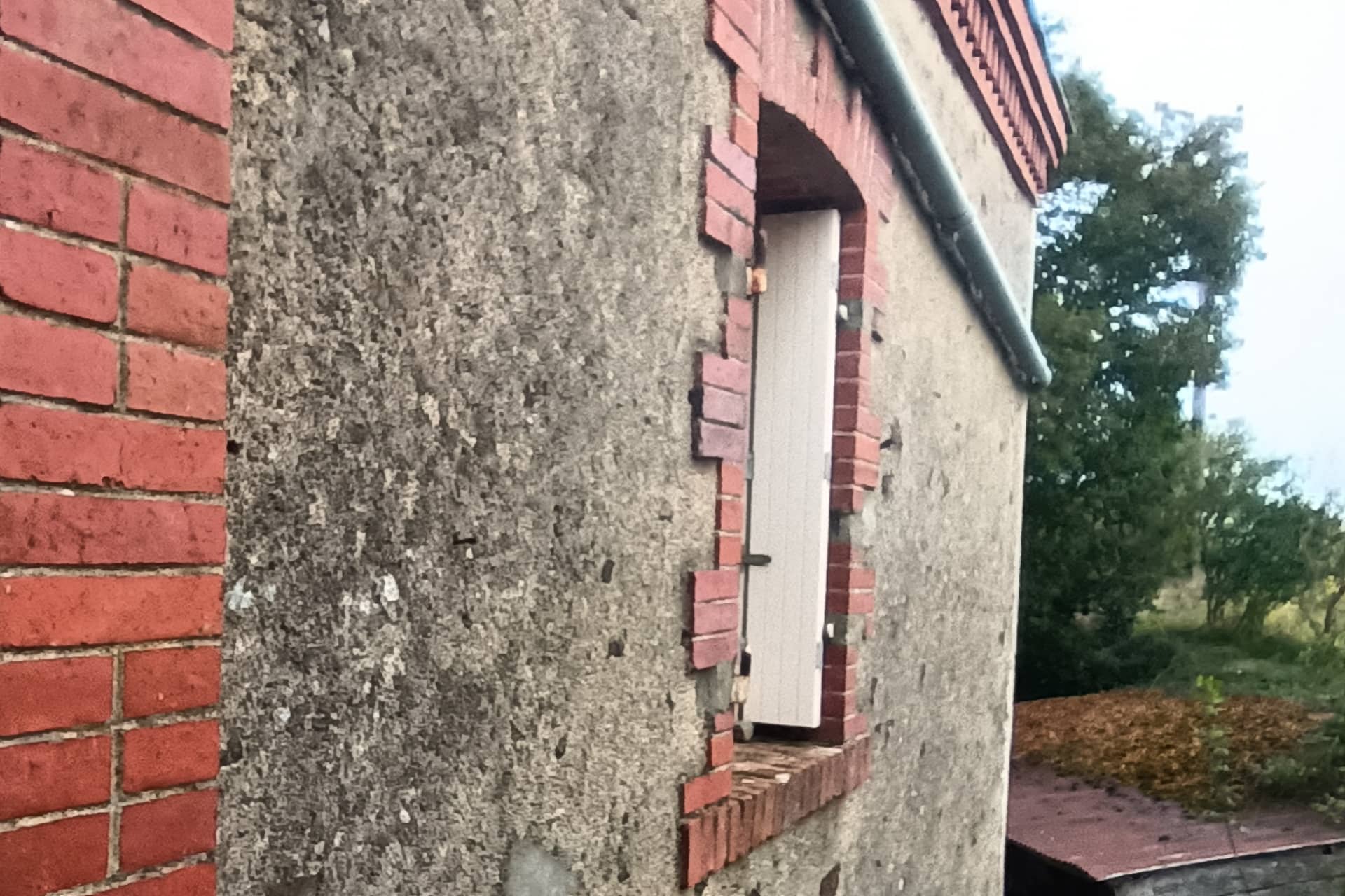 Ravalement de façade d'un mur de maison ancienne avant les travaux